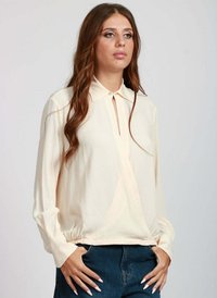 Blusa color crema con colletto, chiusura a bottoni e maniche lunghe. Presenta un orlo arricciato e una texture del tessuto morbida e liscia.
