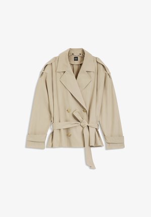 Trench coat bej cu dublu rând de nasturi, revere late, talie cu curea, manșete cu nasturi și epoleți pe umeri, așezat plat pe fundal alb.