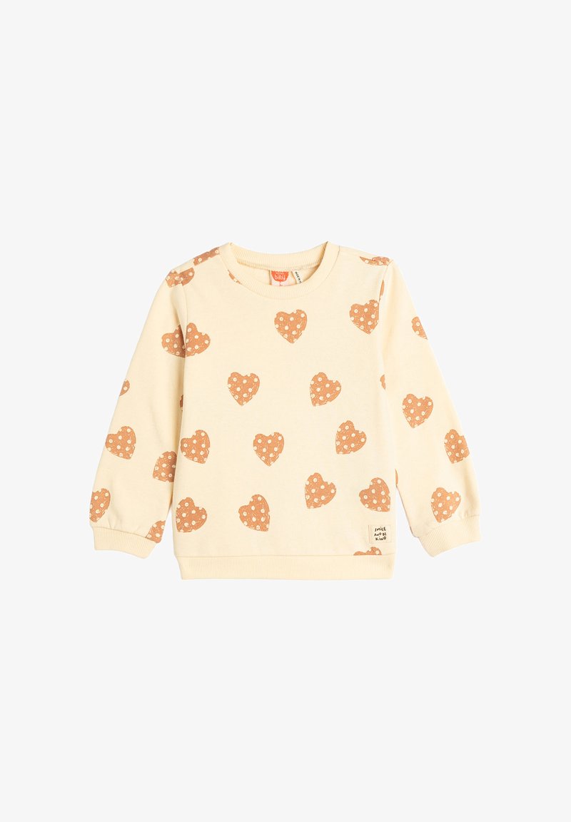 Sudadera beige con corazones a lunares en color óxido, cuello redondo, puños y dobladillo acanalados; fabricada con una tela suave para mayor comodidad.