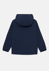 Veste bleu marine avec capuche, fabriquée en matériau léger. Présente des poignets élastiques, un ourlet droit et un design épuré et minimaliste.