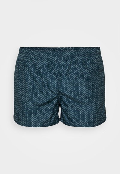 Shorts de bain bleu marine avec un motif en zigzag bleu clair, fabriqués à partir d'un matériau léger avec une taille élastique pour le confort.