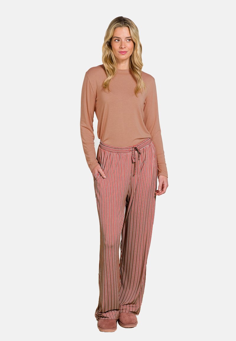 Helles pinkfarbenes Langarmoberteil kombiniert mit rot gestreiften, weit geschnittenen Hosen und beigen Hausschuhen. Die Hose verfügt über einen elastischen Bund mit Kordelzug.