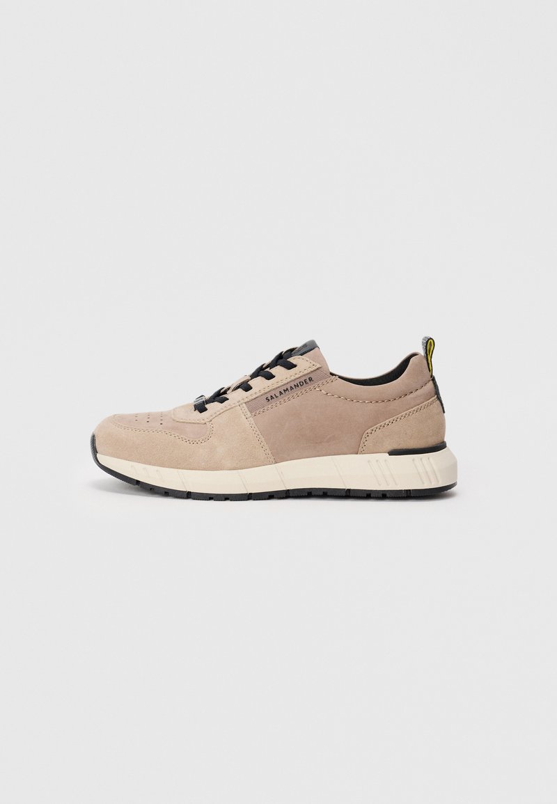 Beige Wildlederschuh mit schwarzen Schnürsenkeln, Gummisohle und Akzentnähten. Verfügt über eine Schlaufe und ein Markenlogo an der Seite.