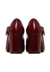 Pantofi cu toc înalt, lucioși, de un burgund strălucitor, cu toc gros și accent de fundiță. Finisaj din piele patent netedă, cu design cu vârf rotunjit.