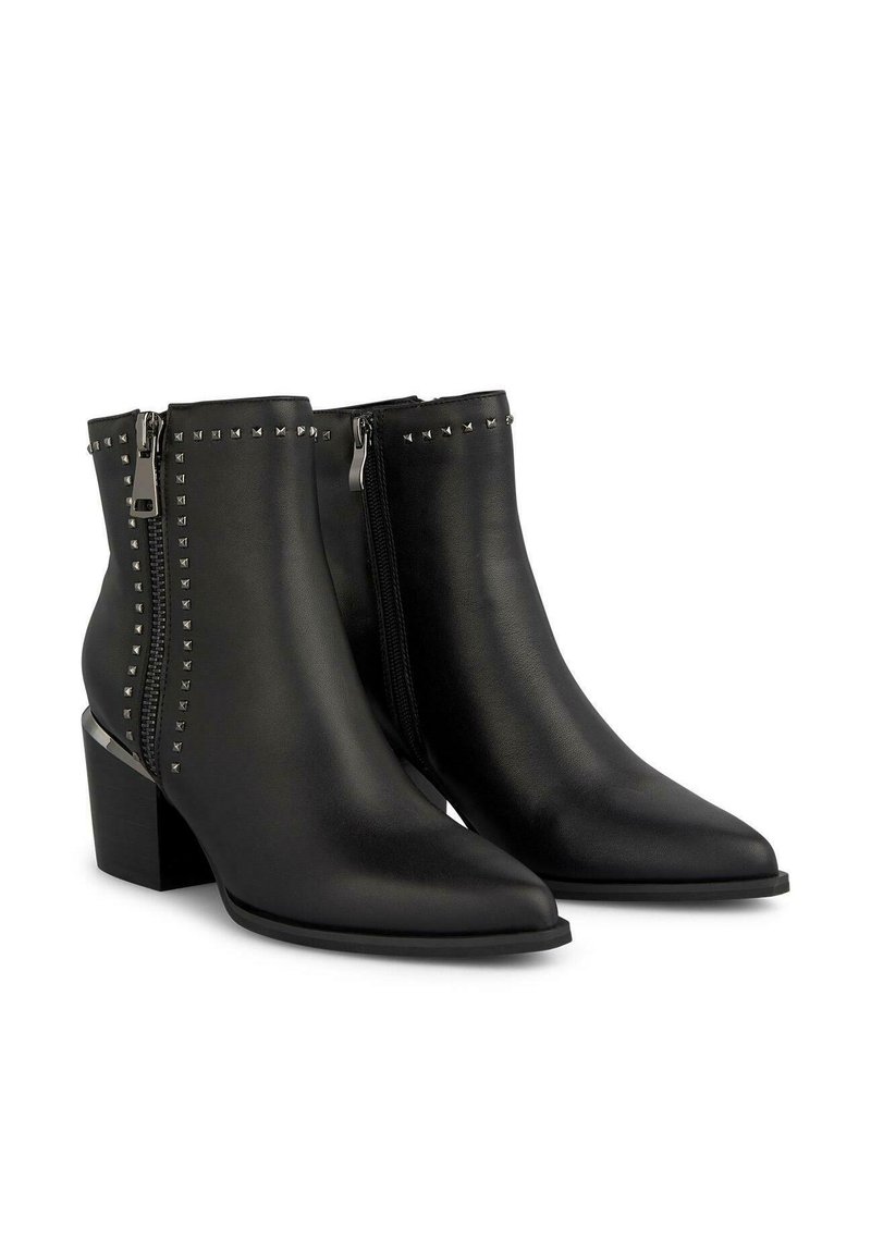 Botas de tobillo de cuero negro con punta afilada, cremalleras laterales y adornos de tachuelas plateadas a lo largo de la costura exterior. Diseño de tacón cuadrado.