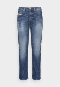 Denim jeans in a medium blue wash, featuring front pockets, a button fly, and slight fading on thighs. Classic straight-leg cut.