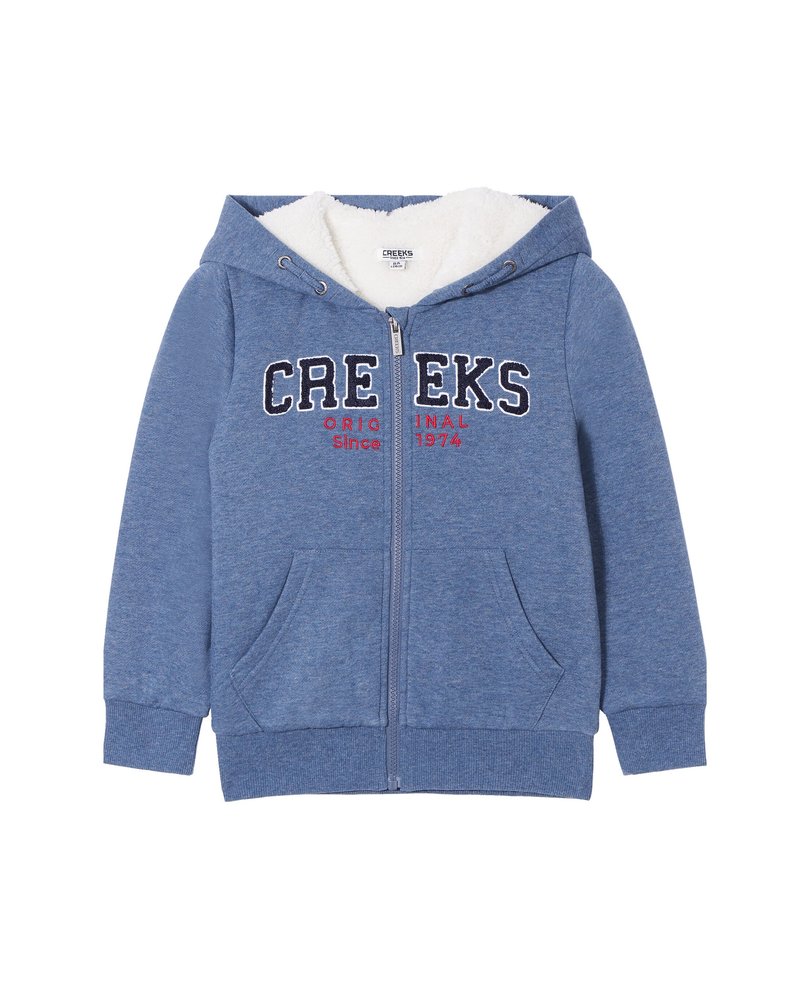Sudadera azul con cremallera hecha de un tejido suave y texturizado, con forro de felpa blanca. Presenta "CREEKS ORIGINAL Desde 1974" en colores contrastantes y dos bolsillos frontales.
