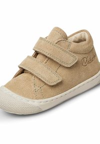 Béžové semišové dětské boty se dvěma nastavitelými suchými zipy, zaoblenou špičkou, bílou gumovou podrážkou a jemnými prošívanými detaily.