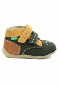 Scarpe per bambini in scamosciato verde e marrone con suola in gomma flessibile, dotate di due cinturini in velcro e dettagli in cucitura bianca.