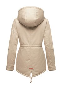 Beige waterdichte jas met capuchon, elastische tailleband en trekkoord. Heeft een gladde afwerking en een logo op de linker mouw.