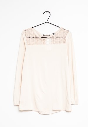 Lys pink langærmet top med et tekstureret blondeland over brystet og rund halsudskæring. Blødt stof med en let buet kant.