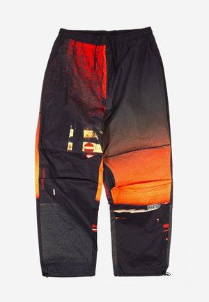 Többszínű tréningnadrágok fekete, narancs és piros árnyalatokban; könnyű anyag grafikai mintával és állítható zsinóros derékkal; cipzáras szárak.