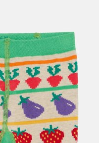 Meias até ao joelho com uma base em bege claro, apresentando detalhes em verde e um padrão de morangos e beringelas em vermelho, roxo e verde.