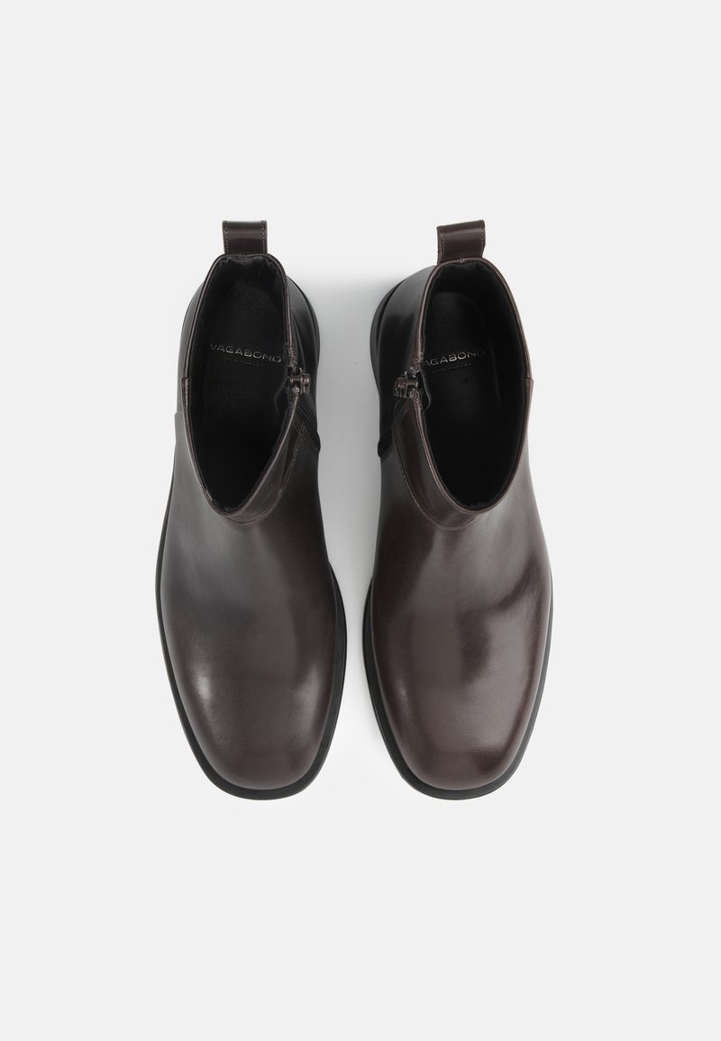 Brown leather ankle boots with a sleek design, rounded toe, and zipper detail on the side. Smooth texture and minimalistic look.