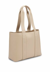 Beige tote bag valmistettu keinonahasta, jossa on kaksi olkahihnaa, tikattu yksityiskohta ja kohokuvioitu brändilogo sivuilla. Suorakulmainen muoto.