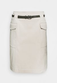 Jupe en coton beige de forme cintrée, dotée de deux poches latérales et d'une ceinture marron avec une boucle en argent. Texture lisse et légère.