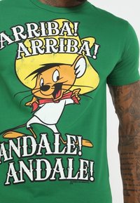 Zielona bawełniana koszulka z postacią z kreskówki w dużym żółtym kapeluszu, towarzysząca tekstowi "ARRIBA! ARRIBA! ANDALE! ANDALE!"