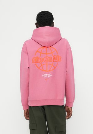 Różowa bluza z kapturem z dużym pomarańczowym globem i napisem „Live On Air” na plecach. Wykonana z bawełny, z kieszenią kangurka i kapturem.