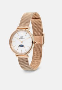 Roséguld mesh armbandsur med en rund vit urtavla, gyllene timmarkörer och en månfasdetalj i blått med stjärnor.