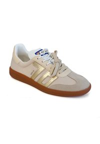 Sneaker beige con punta in morbido suede testurizzato, dettagli dorati ai lati e linguetta bianca con lacci grigio chiaro. Suola in gomma marrone.