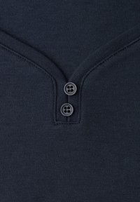 Tejido de punto azul marino oscuro con dos botones oscuros en una pechera de cuello en V estrecho y costuras visibles a lo largo de los bordes.