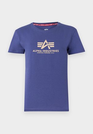 Navy blue cotton t-shirt with short sleeves, featuring a beige logo print "ALPHA INDUSTRIES," and a red inner neck label with text.