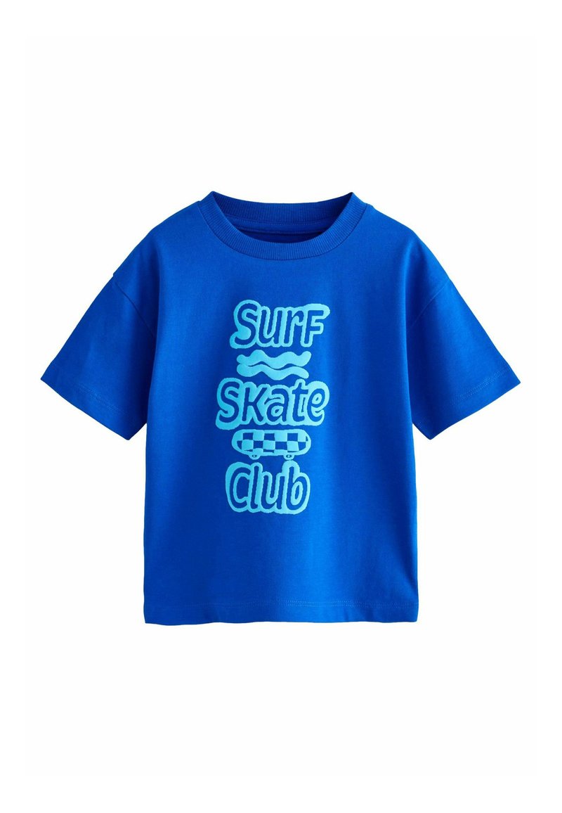 Lyhythihainen sininen t-paita, jossa on "Surf Skate Club" -teksti eri sinisen sävyissä, sekä skeittigrafiikka ja aalto-aksentteja.