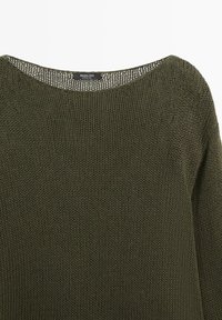 Maglione verde scuro lavorato a maglia con scollo rotondo e etichetta visibile con la scritta "Massimo Dutti Made in China" su sfondo bianco.