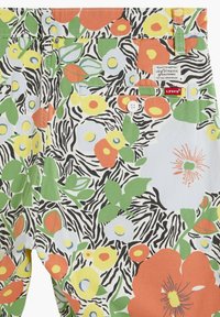 Short à motifs floraux et rayures zébrées avec des feuilles vertes, des fleurs orange, jaunes et blanches, une poche arrière boutonnée et un écusson du logo Levi's.