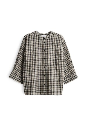 chemise boutonnée matelassée beige avec un motif à carreaux noirs, col rond et manches trois-quarts. Présente des boutons noirs sur le devant.