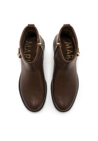 Botas de cuero marrón hasta el tobillo con un acabado suave, que presentan dobles detalles de cremallera dorada y un diseño de punta redondeada. Suela plana negra.