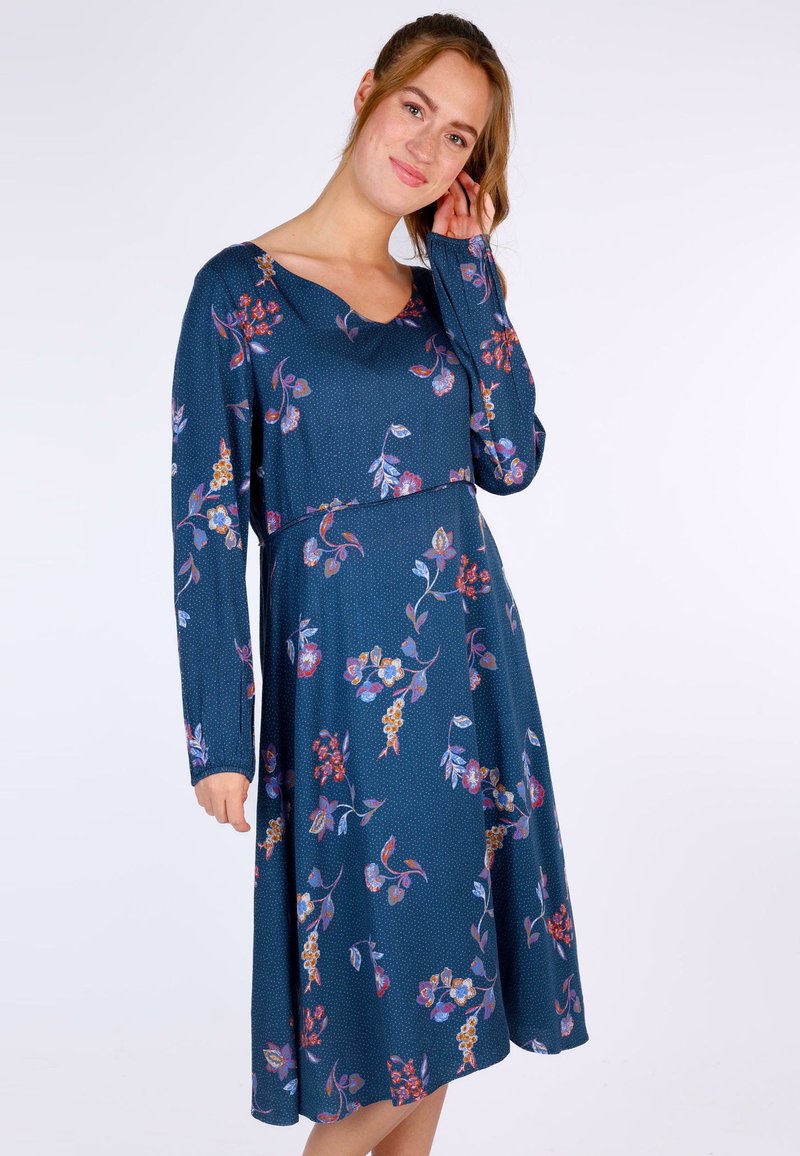 Marineblaues Kleid mit einem floralen Muster in verschiedenen Farben, V-Ausschnitt, langen Ärmeln und einem schwingenden Rock. Glatte Stoffoberfläche.
