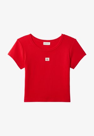 Piros, rövid ujjú, rövidített póló, kerek nyakkivágással és kis fehér Calvin Klein logóval a mellkas közepén.
