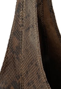 Brązowa torba ze wzorem węża, wykonana ze skórki z teksturowaną powierzchnią, z wyszywanymi szwami i aksamitnym wnętrzem. Trójkątny kształt z minimalistycznym designem.