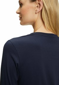 Marineblaue T-Shirt mit Rundhalsausschnitt und langen Ärmeln, aus weichem Baumwollmixstoff, von hinten gezeigt. Glatte Textur, lässige Passform.