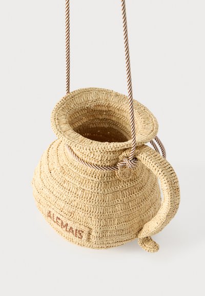 Πλεκτή τσάντα από άχυρο σε σχήμα κανάτας με λαβή, ευρύ άνοιγμα, ριγωτό λουράκι ώμου και το όνομα "ALCMAES" κεντημένο στη πλευρά.