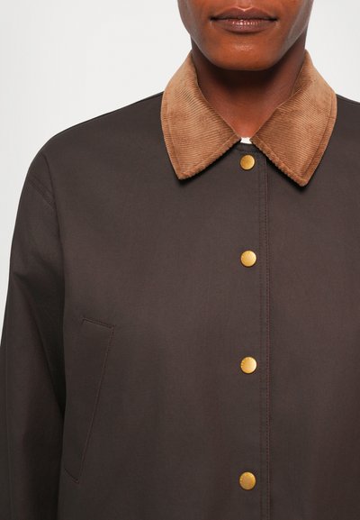 Brown jacket with a corduroy tan collar, gold snap buttons, and a chest pocket. Smooth texture with contrasting materials and colors.