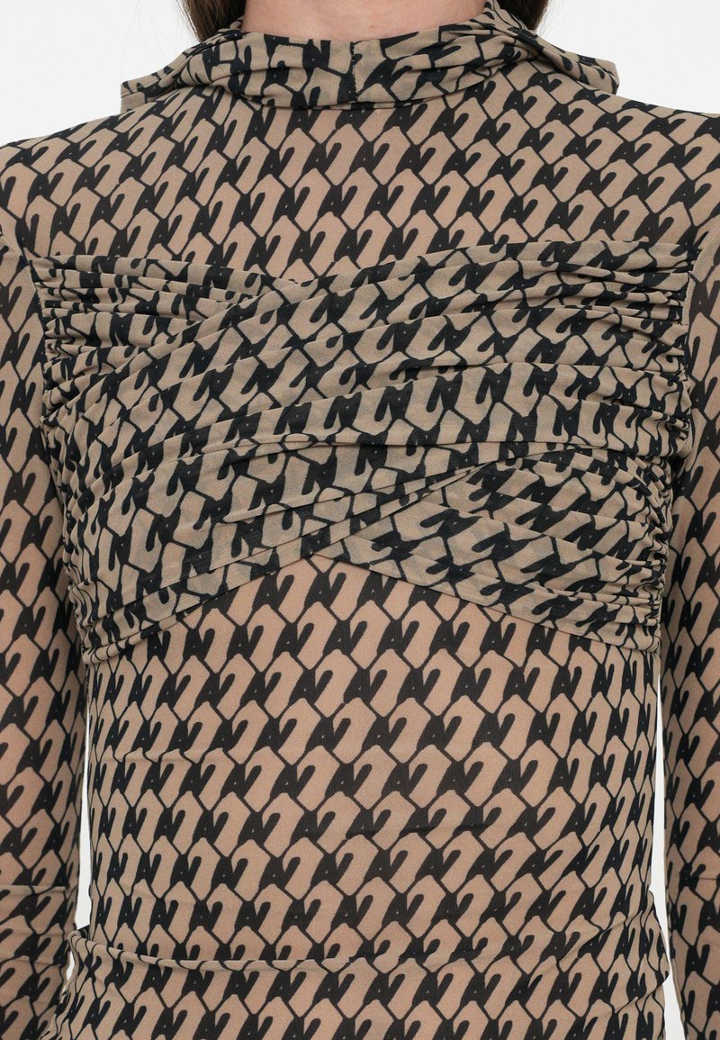 Patroonvolle sheer blouse met een gerimpeld zwart en beige ontwerp, met een hoge kraag en opvallende zwarte accenten. Gelaagd stofwerk.