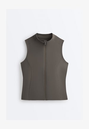 Ærmeløs olivengrøn vest med lynlås og høj krave samt synlige syninger, vist fladt på en hvid baggrund.