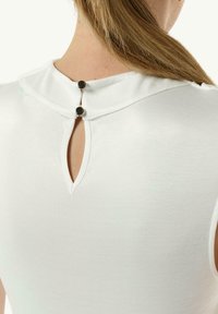 Weiße Bluse mit hohen Kragen und einem Schlüssellochöffnung auf der Rückseite, die mit zwei schwarzen Knöpfen gesichert ist. Glatter, leichter Stoff.