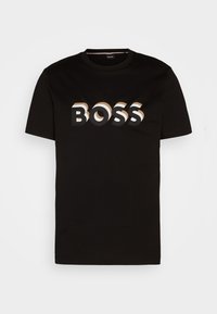 T-shirt en coton noir avec un logo "BOSS" audacieux et multicolore dans une police moderne sur le devant. Col rond et manches courtes.