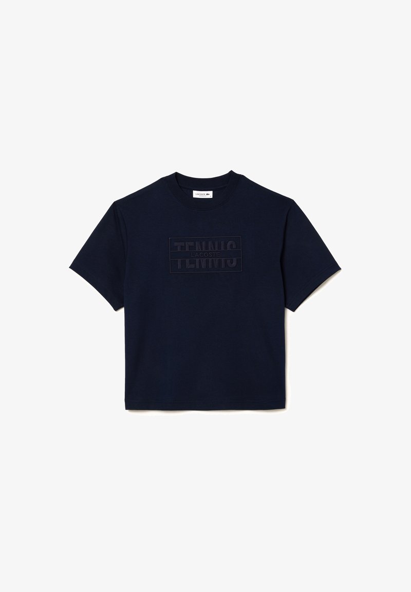 T-shirt en coton bleu marine avec un écusson texturé "TENNIS" et un col rond. Manches courtes et coupe décontractée.