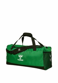 Bolso de viaje verde con acentos negros, hecho de material durable. Cuenta con correa para el hombro, asas en la parte superior y un bolsillo de malla lateral. Logotipo de Hummel exhibido.