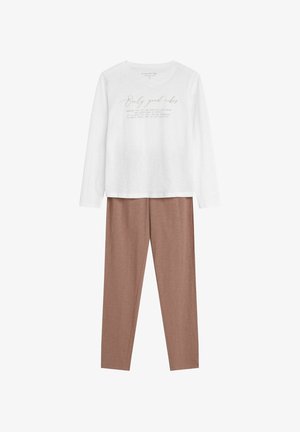 Biała koszula z długim rękawem z napisem "Tylko dobre wibracje", w połączeniu z jasnobrązowymi dopasowanymi spodniami, wykonanymi z miękkiego, gładkiego materiału.