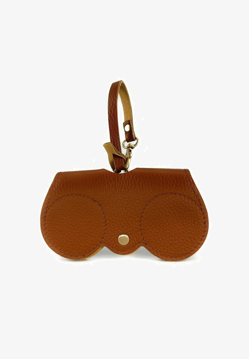 Pochette en cuir brun avec un design arrondi, dotée d'une fermeture à pression et d'une sangle beige. Surface texturée avec deux accents circulaires.