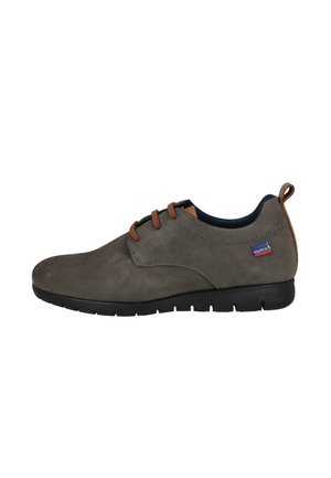 Zapato informal para hombre de cuero marrón con cordones, suela negra, detalles de costura y una pequeña etiqueta de tela "Route 83" en el lateral.