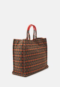 Sac fourre-tout à motif présentant un design géométrique en vert, orange et beige, avec des poignées synthétiques rouges et une forme structurée.