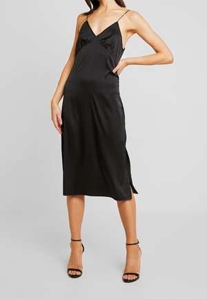 Czarna satynowa sukienka midi z dekoltem w kształcie litery V, cienkimi ramiączkami i bocznymi rozcięciami. Gładka faktura i dopasowany krój tworzą smukłą sylwetkę.