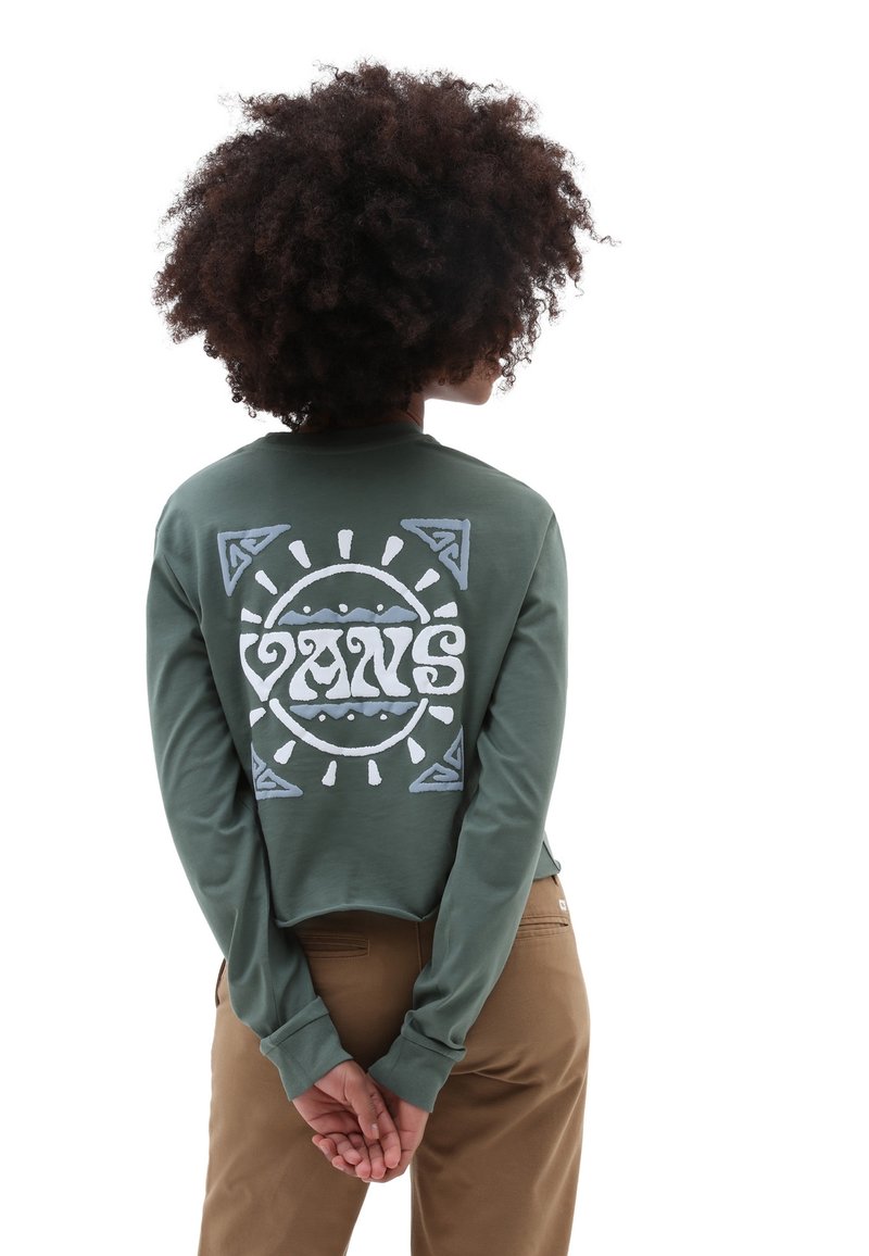 Zielony krótki sweatshirt z długimi rękawami, z dużym białym logo graficznym i okrągłymi wzorami na plecach. Gładka bawełniana tekstura.