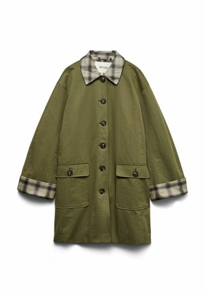 Manteau oversize vert olive avec col et poignets à carreaux, boutons à l'avant, et deux grandes poches à rabat.